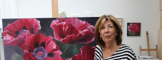 Schilderes Anneke Janszen voor een schilderij met grote rode klaprozen