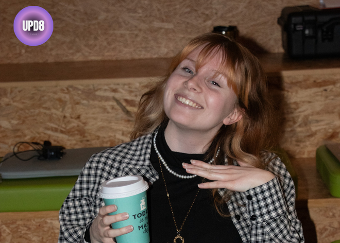 Jonge vrouw met rossig haar in geruite bloes met coffee to go